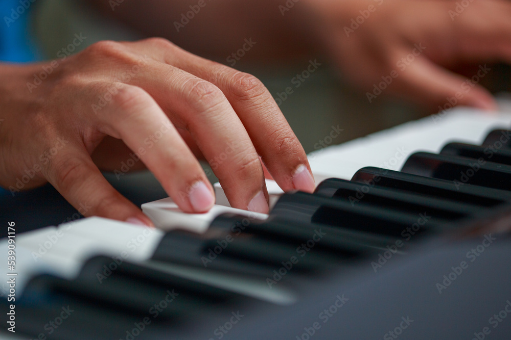 Man playing Electronic piano keyboard. Closeup of black and white piano keys.