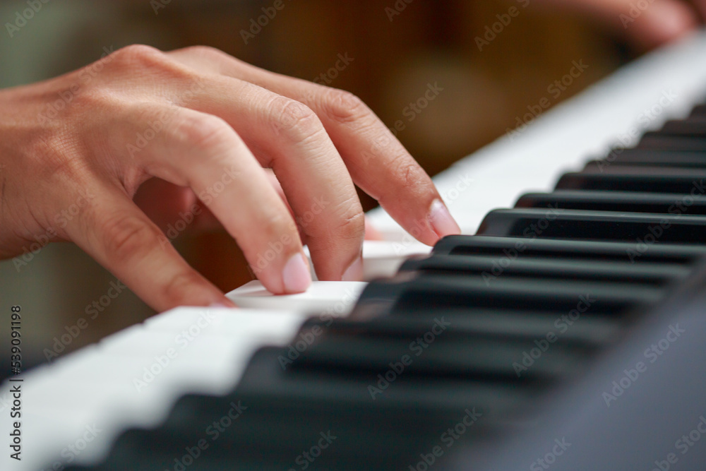 Fototapeta premium Man playing Electronic piano keyboard. Closeup of black and white piano keys.