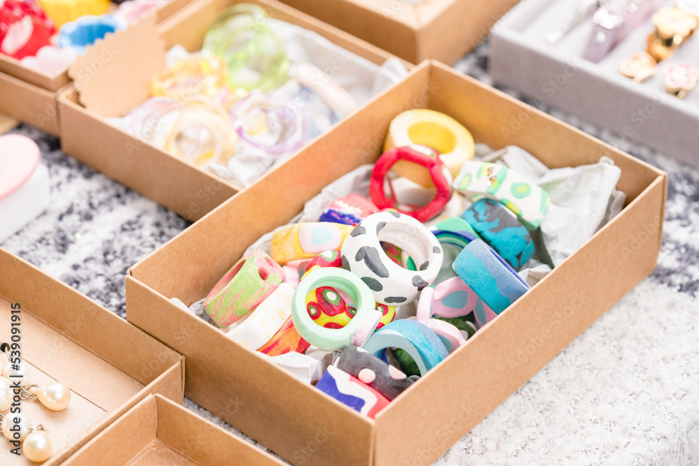 Handmade stone and wooden rings at flea market or garage sale - handmade imitation jewellery for sale. Making jewellery souvenirs. Selective focus Handmade stone and wooden rings at flea market or garage sale - handmade imitation jewellery for sale. Making jewellery souvenirs. Selective focus