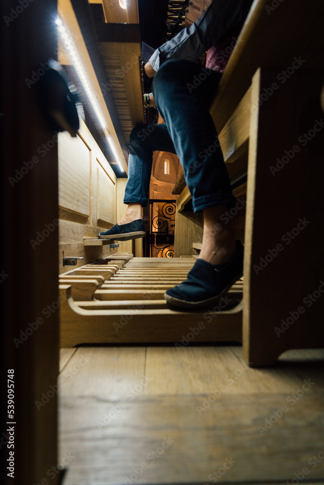 Close-up of a organist playing organ pedals in church Close-up of a organist playing organ pedals in church