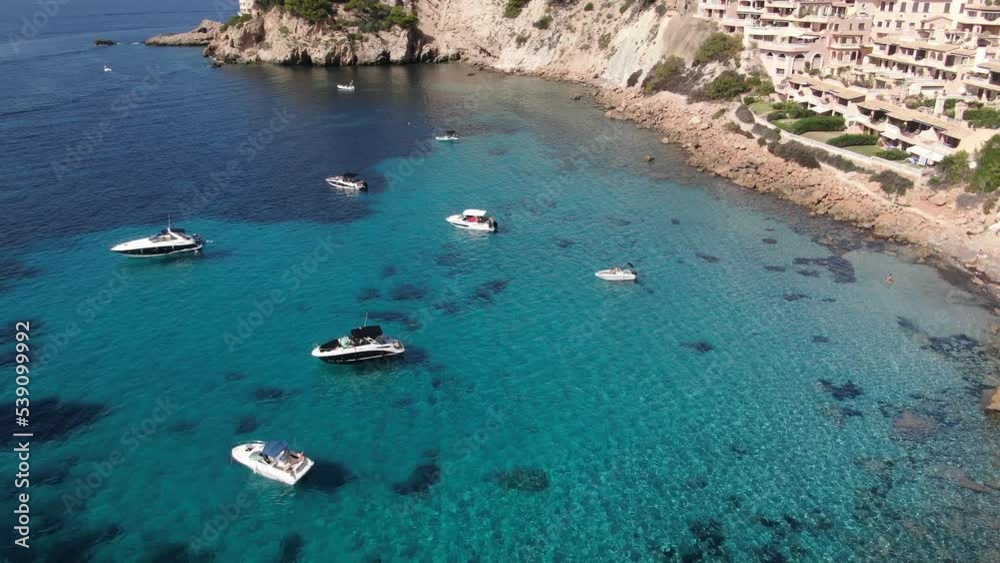 Panoramic view of several yachts and boats anchored in a small bay in the island of Mallorca.. Concept of holidays, luxury a relax Panoramic view of several yachts and boats anchored in a small bay in the island of Mallorca.. Concept of holidays, luxury a relax