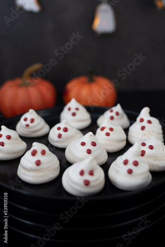 Funny meringue ghosts with funny faces, Halloween dessert