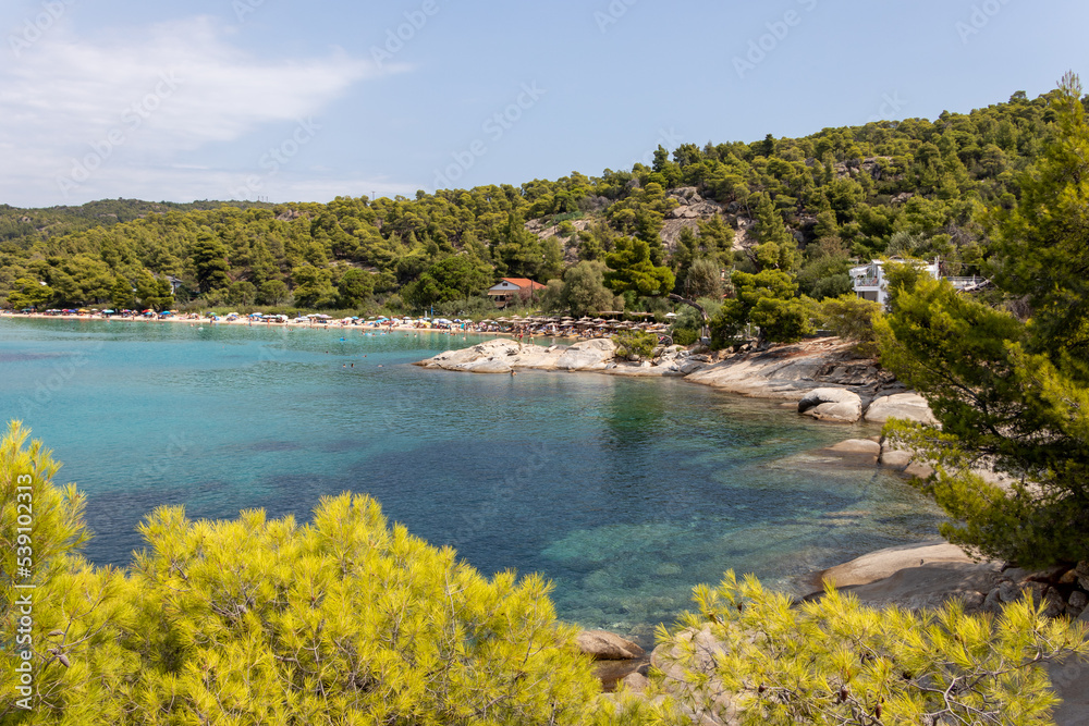 Kalogria Beach in Sithonia, Halkidiki with turquoise shining sea during summer time in Greece. Kalogria Beach in Sithonia, Halkidiki with turquoise shining sea during summer time in Greece.