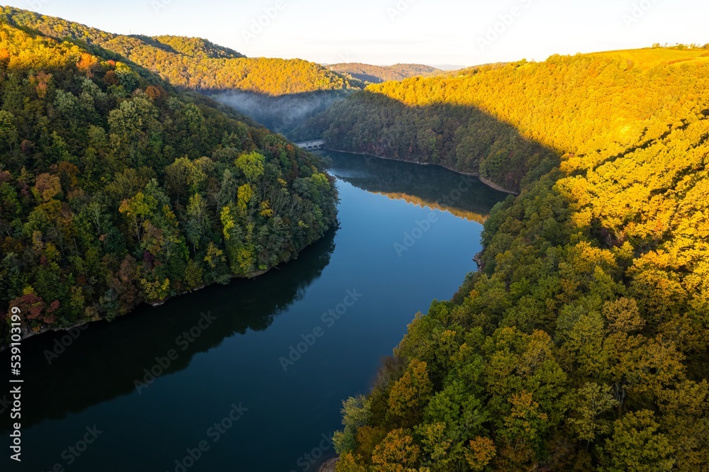 Colorful aerial view of Secu Lake in Caras-Severin - Romania, in the autumn, at sunrise. Scene captured from above, with a drone.