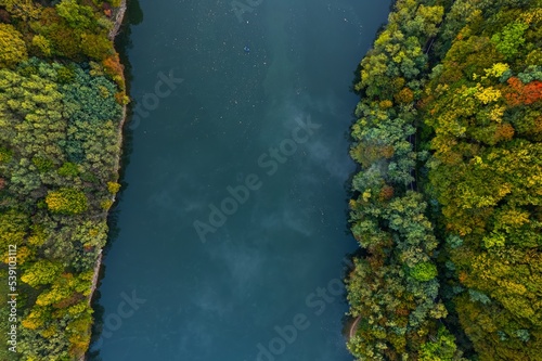 Colorful aerial view of Secu Lake in Caras-Severin - Romania, in the autumn, at sunrise, with visible access road. Scene captured from above, with a drone. © Oană Liviu
