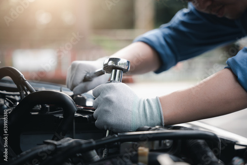Service outdoor. Close up hands of auto mechanic man working on car engine using wrench to repair and maintenance, broken car care check and fixed the problem and services insurance © sorapop