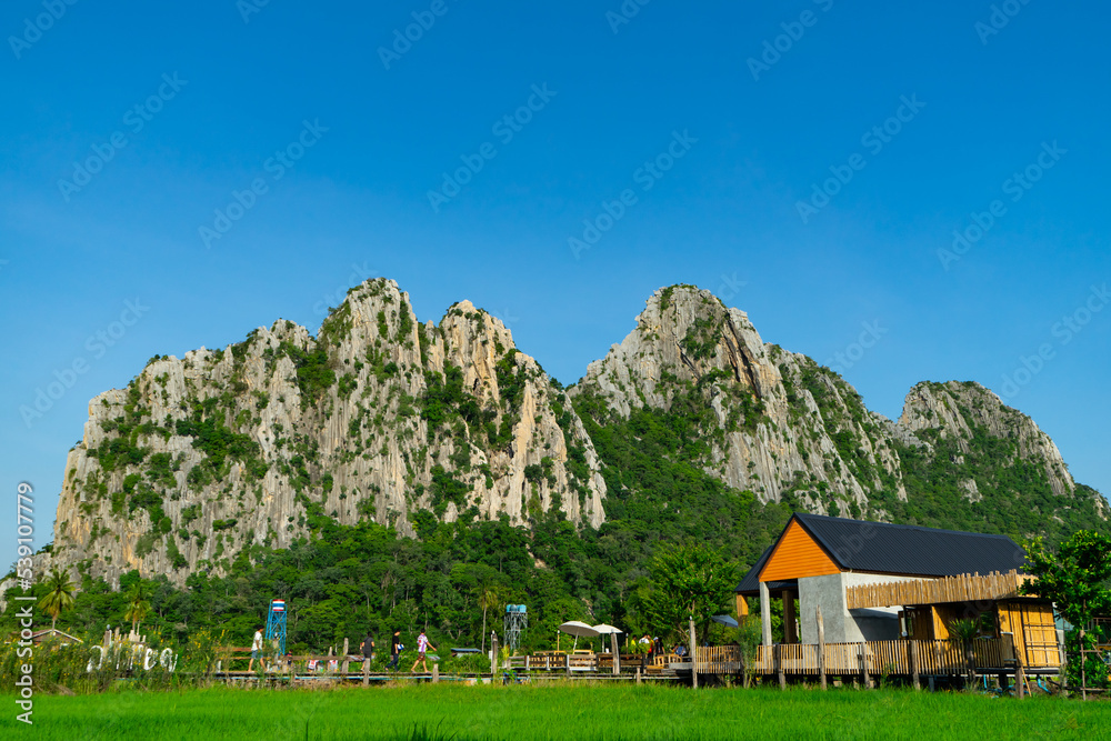 House or restaurant for tourist to visit with KaoNor-KaoKaew mountain background. Limestone ladder climb up to the summit of hill is a viewpoint of sleeping Buddha image cave.Nakhon Sawan,Thailand.