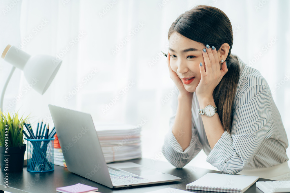 Young Asian woman feeling migraine head strain. Tired, Overworked businesswoman financier while working on laptop computer in office. Young Asian woman feeling migraine head strain. Tired, Overworked businesswoman financier while working on laptop computer in office.
