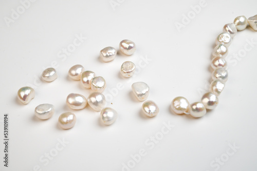 Natural freshwater round pearl beads on white background. Top view