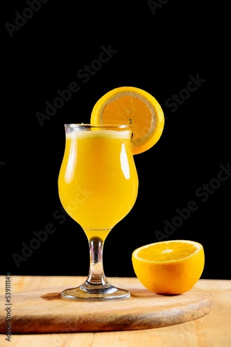 Closeup of orange juice in glass in black background