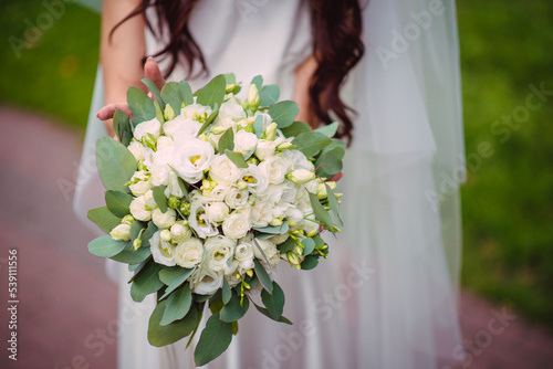 The bride holds a wedding bouquet in her hands, wedding day flowers.