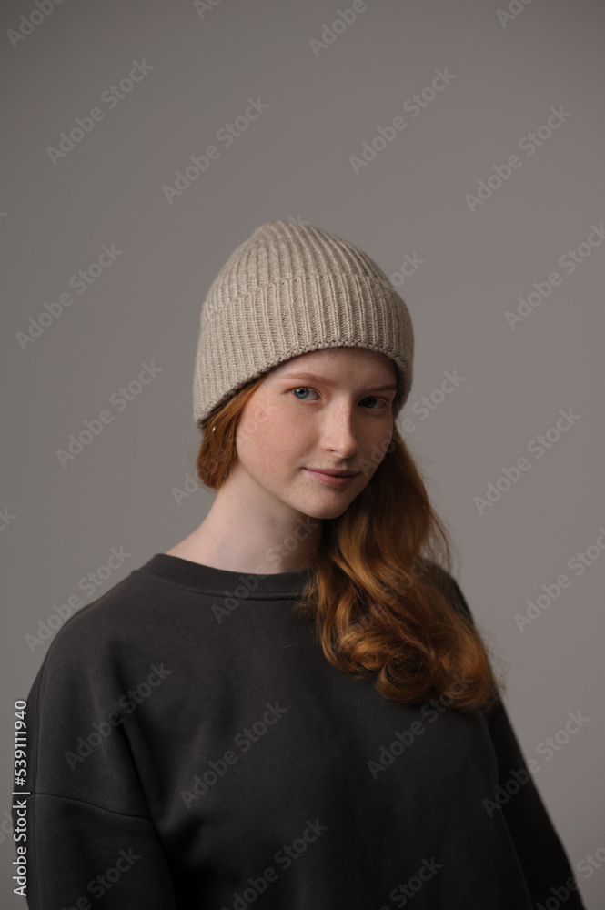 young girl model in beige hipster hat and coat isolated on light background. Product photo mockup for fashion brands and marketplaces, woolen cap, turkish textiles.