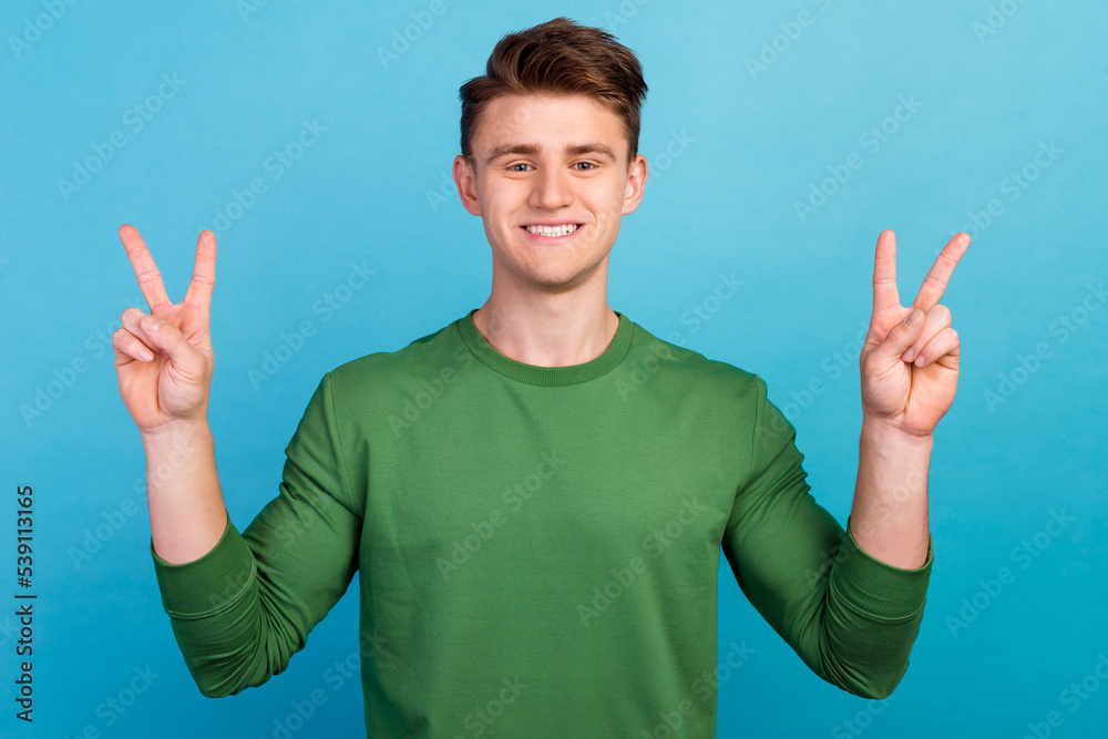 Photo amazing man arms hands show v-sign say hi excited mood wearing casual outfit isolated blue background Photo amazing man arms hands show v-sign say hi excited mood wearing casual outfit isolated blue background