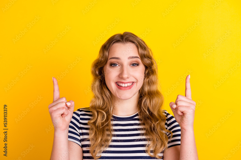 Photo of charming sweet young woman smiling pointing finger empty space isolated yellow color background Photo of charming sweet young woman smiling pointing finger empty space isolated yellow color background