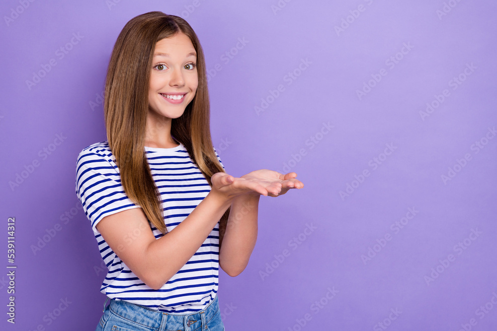 Photo of satisfied glad pleasant girl straight hairdo striped t-shirt palms demonstrating empty space isolated on purple color background Photo of satisfied glad pleasant girl straight hairdo striped t-shirt palms demonstrating empty space isolated on purple color background