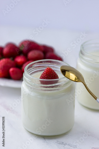 Healthy food at home. Homemade yogurt with strawberries in glass jars