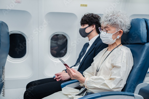 飛行機で旅行をする高齢の女性