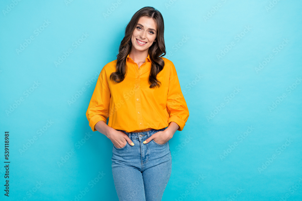 Photo portrait of cute young lady hands pockets shopping defile dressed stylish yellow smart casual look isolated on blue color background Photo portrait of cute young lady hands pockets shopping defile dressed stylish yellow smart casual look isolated on blue color background