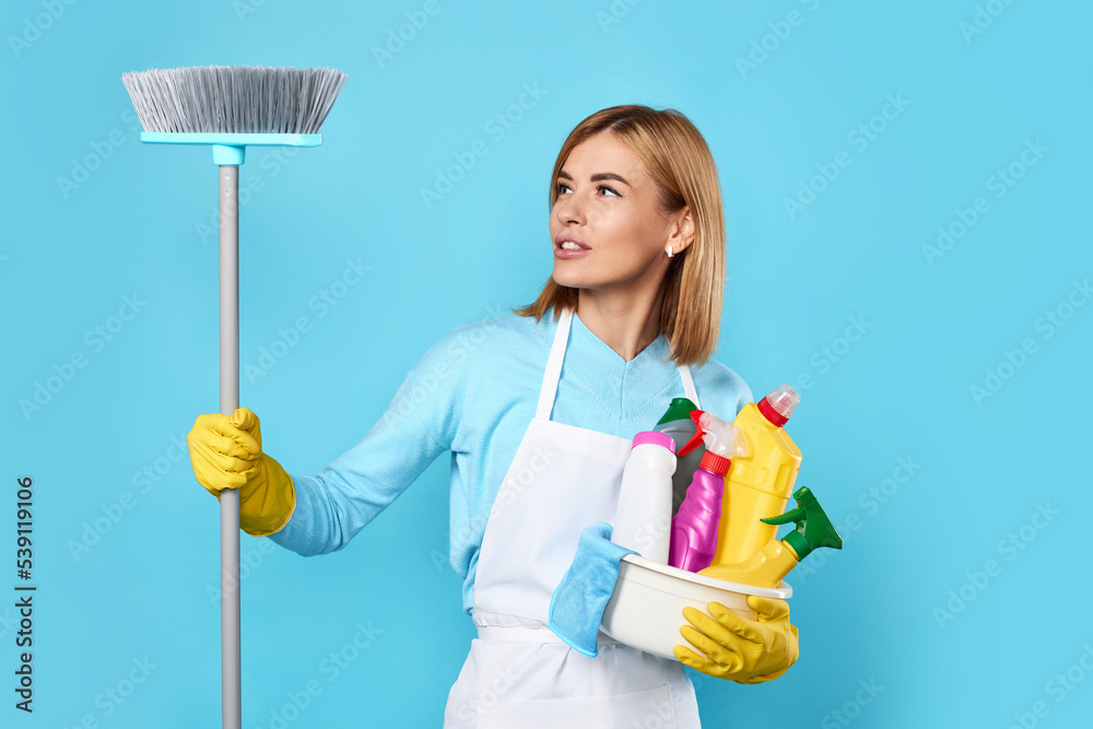 woman in gloves holding bucket of detergents and broom woman in gloves holding bucket of detergents and broom
