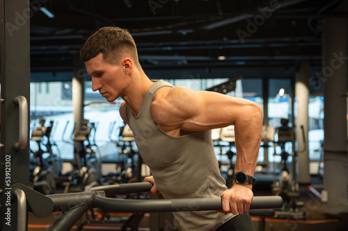 sport muscular man do pushups in fitness gym. pushups practicing muscular man in gym.