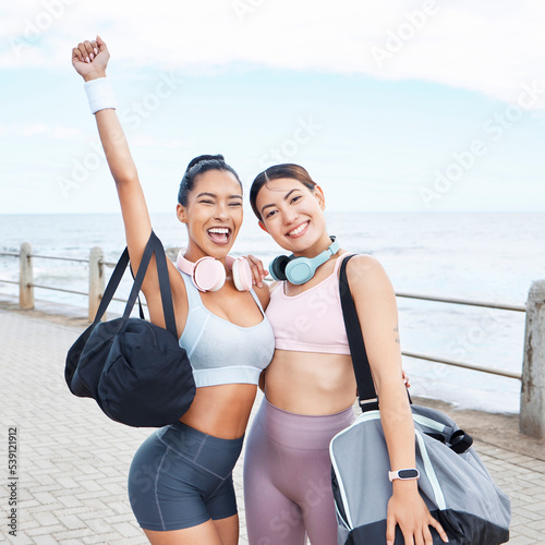 Excited, fitness success and friends exercise by ocean for outdoor training wellness, accountability and happy with body results. Happy sports women with workout bag and headphones for motivation