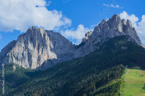 The landscape and the peaks of the Dolomites of the Val di Fassa, one of the most famous and touristic valleys of Trentino, near the town of Canazei, Italy - August 2022. photo