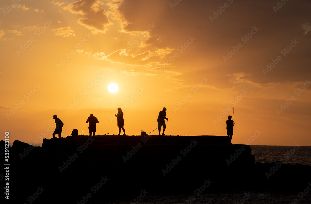 people silhouettes and sunset on the beach