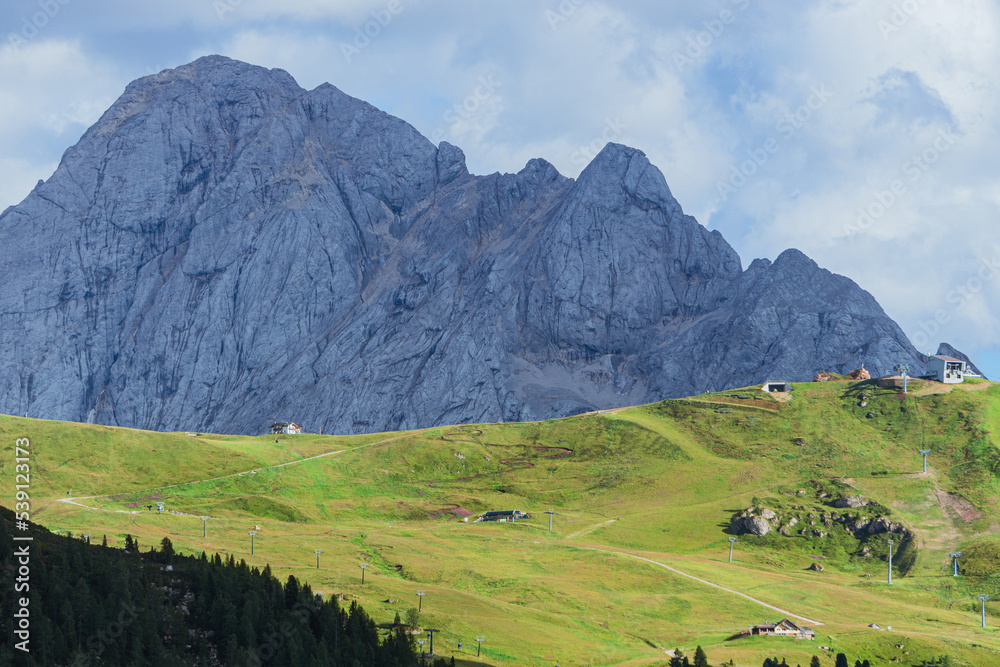 The view of the Dolomites seen from the Sella pass with the lights of the sunset, one of the most famous places in the Alps, near the town of Canazei, Italy - August 2022.