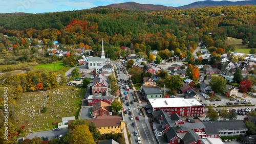Stowe Vermont in autumn splendor. Colorful fall foliage in New England. Aerial establishing shot of ski resort town. photo