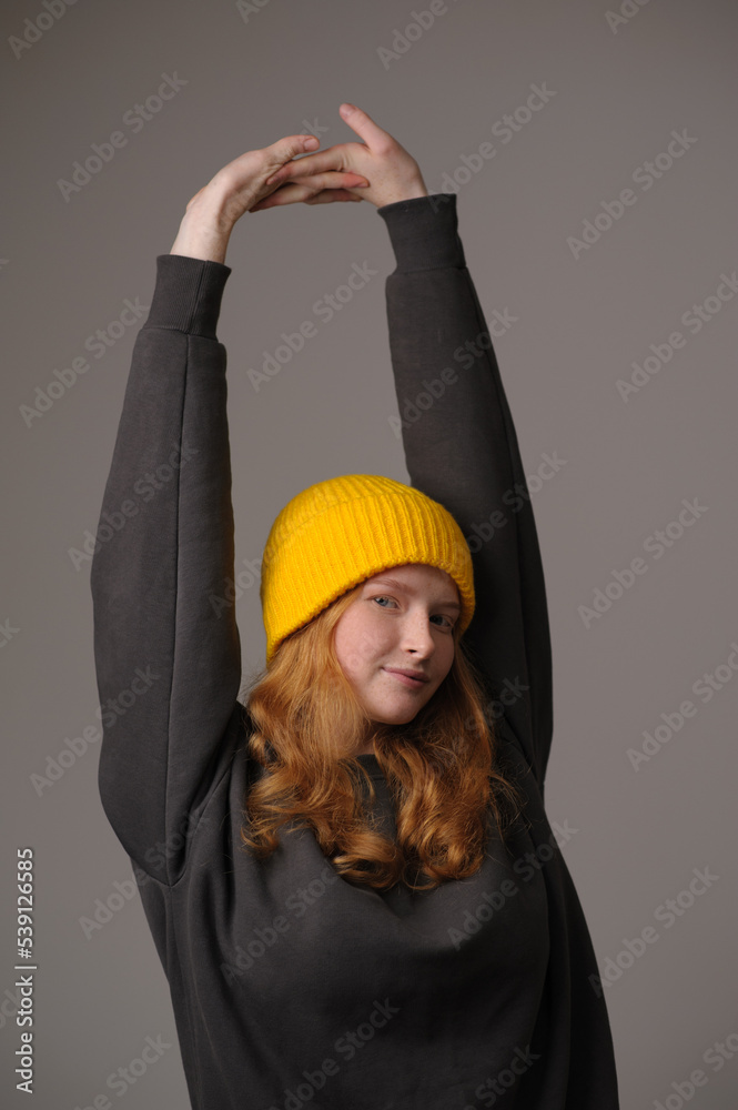 young girl model in yellow cap and gray coat isolated on gray background. Product photo mockup for fashion brands and marketplaces, woolen cap, turkish textiles. young girl model in yellow cap and gray coat isolated on gray background. Product photo mockup for fashion brands and marketplaces, woolen cap, turkish textiles.