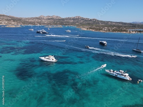 Aerial view of La Maddalena Island, Isola Giardinelli with the drone view of Caprera Island in Sardegna, Italy. Birds eye view of crystalline and turquoise water in north Sardinia, luxury yacht, boat. © AerialDronePics