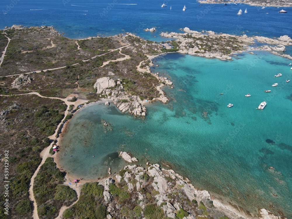 Aerial view of La Maddalena Island, Isola Giardinelli with the drone view of Caprera Island in Sardegna, Italy. Birds eye view of crystalline and turquoise water in north Sardinia, luxury yacht, boat.