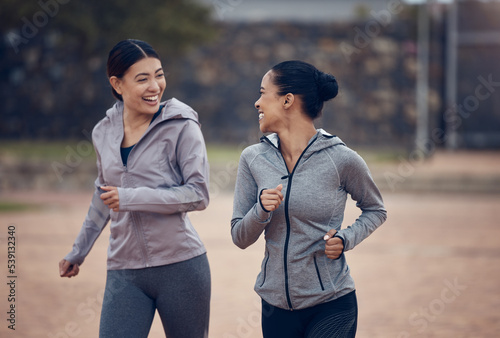 Women, friends and running in city, street or outdoors for fitness, health and wellness. Exercise, diversity and happy girls out for a run, workout or training and talking, speaking or chat together.
