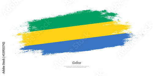 Happy Independence Day of Gabon. National flag on artistic stain brush stroke background.