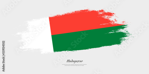 Happy Independence Day of Madagascar. National flag on artistic stain brush stroke background.
