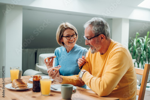 Senior couple eating breakfast at home and spending morning together