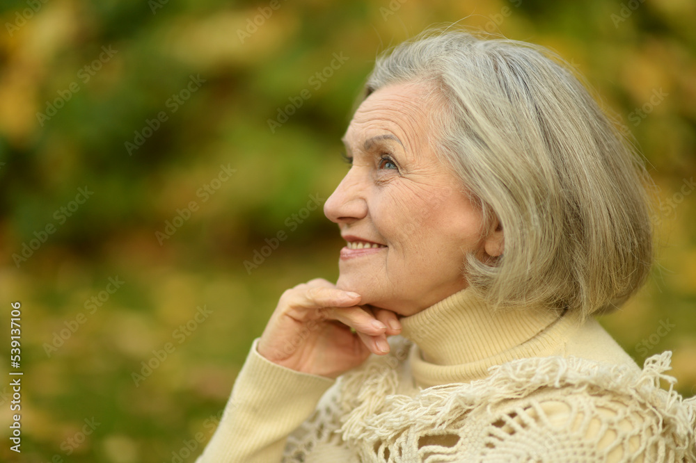 Senior woman walking in the park in autumn
