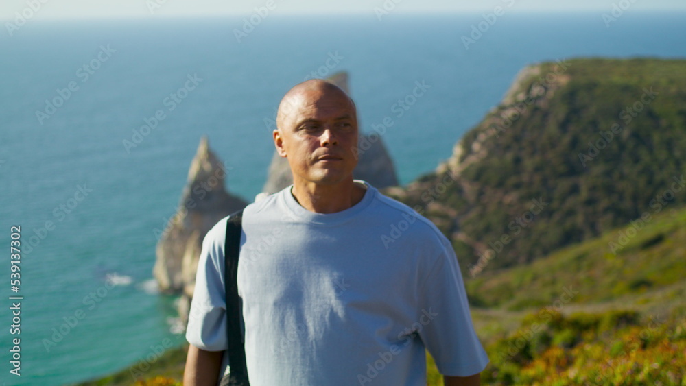 Active man looking spot for yoga workout at amazing summer cliff ocean view. Active man looking spot for yoga workout at amazing summer cliff ocean view.