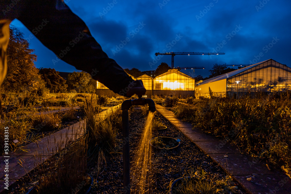 Naklejka premium Copenhagen, Denmark A water faucet at a greenhouse at night.