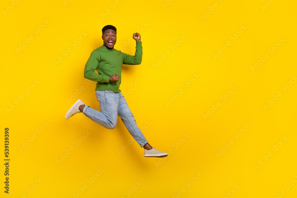 Full length body size view of attractive lucky cheery comic guy jumping rejoicing isolated over vivid yellow color background Full length body size view of attractive lucky cheery comic guy jumping rejoicing isolated over vivid yellow color background