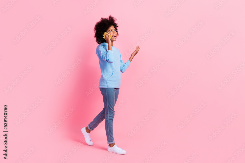 Full body profile photo of cheerful schoolgirl walking speak communicate telephone isolated on pink color background Full body profile photo of cheerful schoolgirl walking speak communicate telephone isolated on pink color background