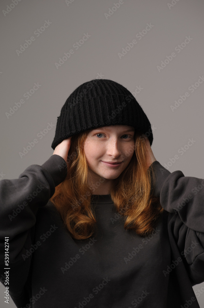 young girl model in black cap and coat isolated on grey background. Product photo mockup for fashion brands and marketplaces. young girl model in black cap and coat isolated on grey background. Product photo mockup for fashion brands and marketplaces.
