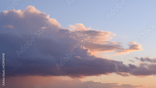 White big fluffy clouds. Natural scenic abstract background. Weather changes backdrop. Sky filled with voluminous clouds. Colorful clouds on sunset or sunrise.