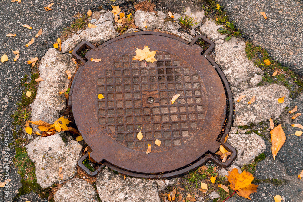 Old iron manhole cover on the street sewer cap Old iron manhole cover on the street sewer cap