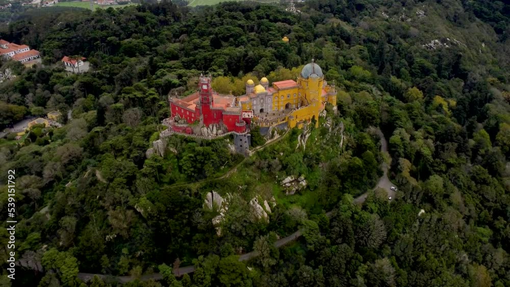 Beautiful Pena Palace situated on the top of a hill in the Sintra Mountains above the town of Sintra. The palace is UNESCO World Heritage Site and one of the Seven Wonders of Portugal. Drone backward Beautiful Pena Palace situated on the top of a hill in the Sintra Mountains above the town of Sintra. The palace is UNESCO World Heritage Site and one of the Seven Wonders of Portugal. Drone backward