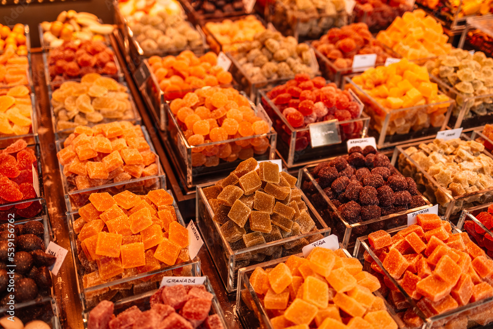 Fototapeta premium Market stall full of color fruit candy in La Boqueria Market. Barcelona. Catalonia. Market street shops