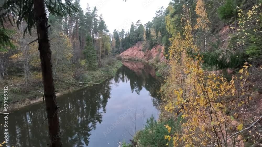 Nelku Red Sandstone Cliffs at the River Salaca in Skanaiskalns Nature Park in Mazsalaca in Latvia, Autumn Time. Sandstone Geological Formation Nelku Red Sandstone Cliffs at the River Salaca in Skanaiskalns Nature Park in Mazsalaca in Latvia, Autumn Time. Sandstone Geological Formation