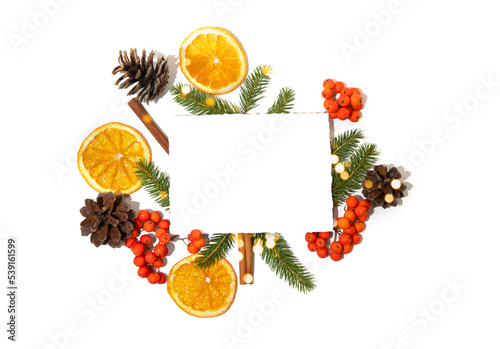 A white sheet of writing paper is decorated with fir branches, dry orange slices and golden toys. New Year, Christmas flat lay