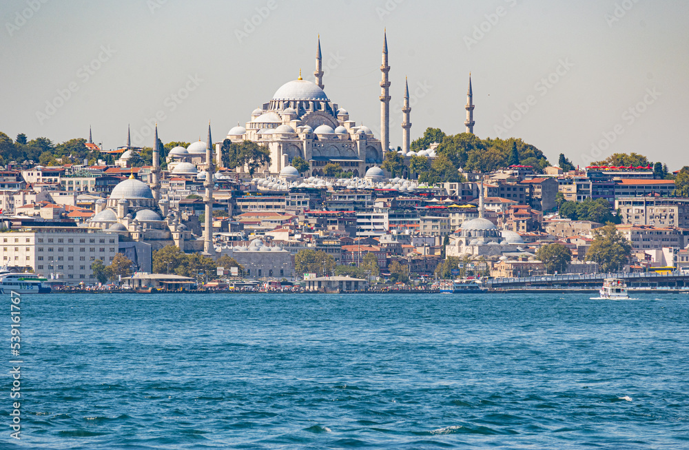 Obraz premium Big cargo ships crossing the Bosphorous through Istanbul with Agia Sofia in the background