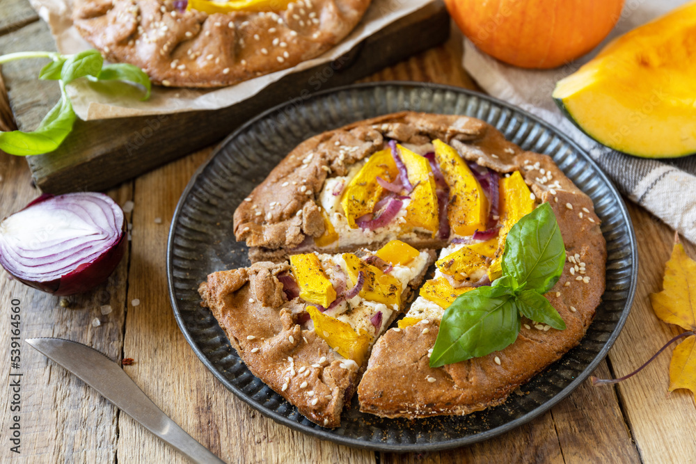 Homemade galette pie or crostata with pumpkin and ricotta cheese on rustic background. Thanksgiving day food. Homemade galette pie or crostata with pumpkin and ricotta cheese on rustic background. Thanksgiving day food.